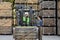 Happy young bearded guy driver in helmet in forklift truck with box full green apples