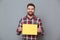 Happy young bearded man holding copyspace blank