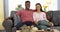 Happy young black couple relaxing on couch looking at camera