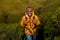 Happy young black man hiking in nature with backpack