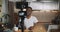 Happy young black popular social media blogger man live streaming for his online blog using camera at home slow motion.