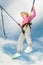 Happy young blonde girl bouncing while attached to bungee cords