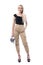 Happy young blonde woman with handbag wearing military ocker pants posing