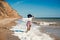 Happy young boho woman walking and having fun in sea waves in sunny warm day on tropical island. Summer vacation. Space for text.