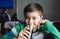 Happy young boy drinking glass of cold drink, Portrait Child with smiling face sitting in cafe drinking soda or soft drink,