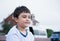 Happy young boy with smiling face, Positive child relaxing outdoor in sunny day summer, Side view portrait mixed race kid sitting