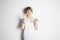 Happy young boy in white T-shirt posing like tiger in front of white empty wall. Portrait of fashionable male child