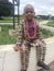 Happy young brother wearing traditional print attire with beads seats at an open Ota Assembly of the Jehovahs Witnesses in Nigeria