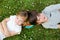 Happy young brothers lying on grass