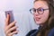Happy young brunette woman in glasses talk a video chat on a mobile phone, face close-up.