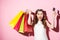 Happy young brunette woman holding credit card and shopping bags