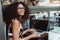 Happy young businesswoman in glasses in an outdoor cafe with her netbook and a cup of coffee; a cheerful curly caucasian female