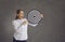 Happy young businesswoman holding dartboard target with red dart right in bullseye