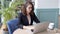 Happy young businesswoman using laptop computer in a cafe