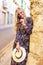 Happy young carefree fashionable woman posing at wall on street