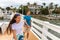 Happy young casual couple tourists walking on Florida boardwalk in Marina enjoying summer day holding hands. Interracial