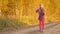 Happy young caucasian girl blowing soap-bubbles outdoors. Golden autumn trees background.