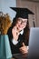 Happy young caucasian woman celebrating college graduation during a video call with friend or family