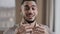 Happy young coach arab man blogger wears wireless earphones say hello at camera subscribers record lifestyle blog use wi