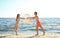 Happy young couple in beachwear playing with inflatable ball