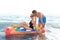 Happy young couple in beachwear swimming with inflatable mattress