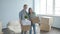 Happy young couple with cardboard boxes moves to new apartment