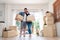 Happy young couple Carrying cardboard boxes and standing in the front door of a new house at moving day. Concept of relocation,