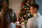 Happy young couple celebrates New Year holiday near decorated Christmas tree at home