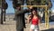 Happy young couple clowning around with a wig on a playground