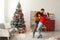 Happy young couple dancing near Christmas tree