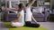 Happy young couple doing yoga together bending body backwards in pairwork