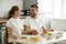 Happy young couple enjoying having breakfast at home kitchen tab