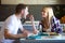 Happy young couple enjoying lunch while woman is feeding her boyfriend in the kitchen.