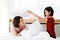 Happy young couple friend beautiful asia women having a pillow fight in their bedroom