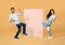 Happy young couple gesturing next to huge shopping bag