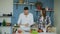 Happy young couple in the kitchen. Attractive dancing man cooking while his girfriend help him in the morning
