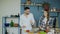 Happy young couple in the kitchen. Attractive dancing man feeding his girlfriend while she is cooking in the morning