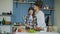 Happy young couple in the kitchen. Attractive woman cooking while her boyfriend kissing her in the morning