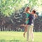 Happy young couple in love enjoys spring day, loving man holding on hands his woman carefree walking in park