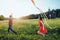 Happy young couple in love runing a kite on the field. Two, man and woman smiling and resting in the country side