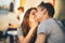 Happy young couple in love teenagers friends dressed in casual style kissing in street cafe on sunset