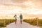 Happy young couple in love walking on romantic beach stroll at sunset. Lovers holding hands on Florida vacation holidays