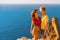 Happy young couple man and woman embrace on the edge of a cliff on the Cape, family youth travel concept