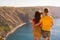 Happy young couple man and woman embrace on the edge of a cliff on the Cape, family youth travel concept