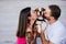 Happy young couple outdoors kissing their beagle dog. Family and lifestyle concept