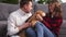 Happy young couple playing and relaxing with pet dog beagle at home. Portrait of caucasian man and woman in love feeding