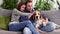 Happy young couple playing and relaxing with pet dog beagle at home. Portrait of caucasian man and woman in love feeding