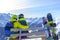 Happy young couple sitting on a bench with snowboards a snowy slope and looking at a landscape of snowy Alps.