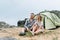 Happy young couple travelers in casual outfits put tent in mountains. Local tourism, weekend trip concept