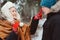 happy young couple walking in winter snowy forest in warm knitted gloves